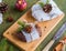 Lithuanian dessert, sweet apple fruit candy in the form of heads of cheese with spices on a wooden board on a green background