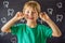 Litle caucasian boy holds a dropped milk tooth between his fingers and laughs looking into the camera