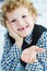 Litle caucasian boy holds a dropped milk tooth between his fingers and laughs. Selective focus on the tooth.