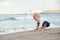 Litlle boy playing on the beach with a ship. Summer vacation and