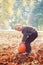 Little adorable boy is hugging a huge pumpkin in autumn garden.