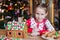 Little adorable girl with decorating gingerbread