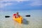 Little adorable girl kayaking in the clear blue