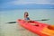 Little adorable girl kayaking in clear blue sea