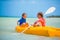 Little adorable girls enjoying kayaking on yellow kayak