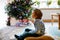 Little adorable preschool kid boy watching television, indoors. Lonely alone child enjoying cartoons on tv during corona