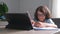 Little adorable school boy with eyeglasses, studying online from home. kid using digital tablet