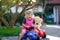 Little adorable toddler girl driving toy car and having fun with playing with plush toy bear, outdoors. Gorgeous happy