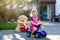 Little adorable toddler girl driving toy car and having fun with playing with plush toy bear, outdoors. Gorgeous happy