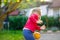 Little adorable toddler girl playing with ball outdoors. Happy smiling child catching and throwing, laughing and making