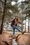 A little adventure does wonders for the soul. a young woman walking on a tree log in the wilderness during winter.