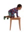 Little African-American boy climbing up  on white background. Danger at home
