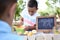 Little African-American boy preparing fresh lemonade in park