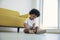 A Little African American boy sitting on the floor and playing beaten the small xylophone