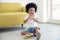 A Little African American boy sitting on the floor and playing beaten the small xylophone