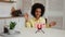 Little African American girl records a funny video using a smartphone. The black child is having fun, making funny faces