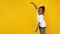 Little african-american girl`s portrait isolated on yellow studio background