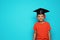 Little African-American school child with graduate cap