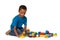 Little african boy playing with lots of colorful plastic blocks indoor. Isolated