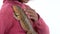 Little african curly girl is holding and stroking Bearded agama at white background. Close up. Slow motion