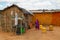 little african girl from maasai tribe standing near her clay house poverty