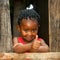 Little african girl at wooden fence with thumbs up.