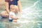 Little Asian 10 months baby excited playing the beach first time. Mother closely take care baby while playing the water