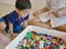 Little Asian baby being interested looking at colorful interlocking plastic bricks toy