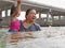 Little Asian baby girl enjoys playing water in a river with her auntie