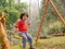 Little Asian baby girl enjoys riding a swing at a playground