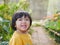 Little Asian baby girl enjoys staying inside a covered greenhouse flora garden