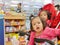 Little Asian baby girl front getting bored waiting for a long time in a baby stroller for her mother buying drugs a pharmacy