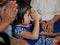 Little Asian baby girl paying respect, wai, to the elders during Rod Nam Dam Hua ceremony in Songkran festival in Thailand