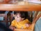 Little Asian baby girl sitting and playing / exploring under a dinning table during a meal with her family at a restaurant