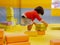 Little Asian baby girl stacking up foam building bricks / blocks at an indoor playground