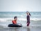 Little Asian boy and girl play waves on the beach