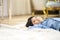 Little asian boy lying on back on carpet