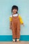Little asian child. Cute Asian girl in a brown bib dress Smiling brightly and wearing slippers