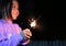 Little Asian child girl enjoy playing firecrackers. Focus at fire sparklers