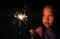 Little Asian child girl enjoy playing firecrackers. Focus at fire sparklers