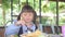 Little asian child girl having breakfast at the morning with a happy smiling face