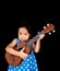 Little asian child play the ukulele