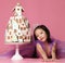 Little asian girl in crown and purple dress with ginger cookie cake for birthday party celebration