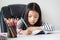 Little Asian girl doing homework for self learning and education concept select focus shallow depth of field