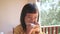 Little asian girl eating bread in the morning. Cute little girl having breakfast at home.