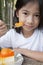 Little Asian girl enjoy orange cheese pie.