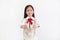 Little asian kid girl give you a gift box on white background. Happy new year and Merry christmas concept. Focus at child face