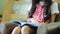 Little Asian students in red dress reading book in library