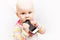 Little baby baby chews on a mobile phone