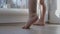 little baby barefoot legs heels toes on wooden floor tiptoes learn stand still